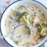 cheesy broccoli soup with spoon in bowl