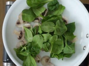 spinach and mushrooms in frying pan