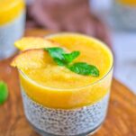 peach chia pudding with mint leaf on top and sliced peaches as garnish