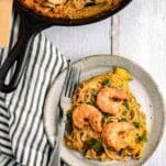 pan with creamy zucchini topped with Mediterranean shrimp