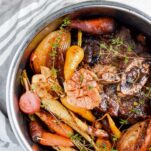 Instant Pot with beef, garlic, herbs, onion, carrots and radishes